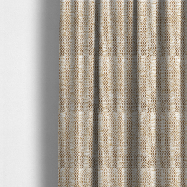 The fabric used to create these made-to-measure curtains is a textured, multi-tonal beige and tan fabric. The material features a tight, intricate weave that creates a pebbled or "seed stitch" appearance. The colour is a warm sand or wheat palette, achieved by interlacing light cream threads with darker tan or straw-coloured fibres, giving the fabric a rich, organic depth.