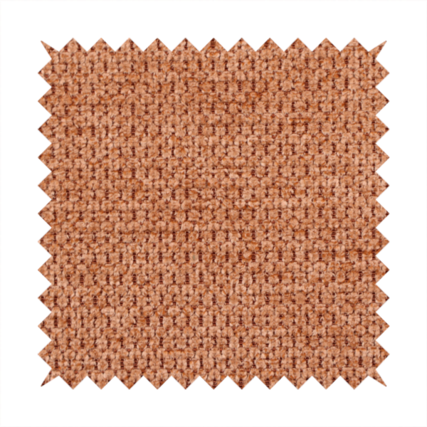 A textured, deep terracotta or burnt orange fabric. This material features a dense, uniform weave with a tactile, honeycombed surface. The colour is a rich, saturated earth tone, created by tightly interlacing copper-coloured threads that catch the light, giving the fabric a subtle, warm glow and a complex, pebbled depth.