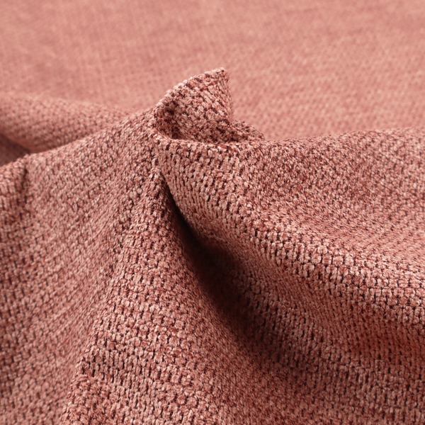 A textured fabric in a muted rose or dusty clay tone. The material features a dense, rhythmic weave with a tactile, pebbled surface. The colour is a sophisticated, warm mauve, created by interlacing deep pinkish-brown threads with lighter rose fibres, giving it a weathered, multi-dimensional look.