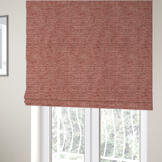 The fabric used to create these Roman blinds is a textured fabric in a muted rose or dusty clay tone. The material features a dense, rhythmic weave with a tactile, pebbled surface. The colour is a sophisticated, warm mauve, created by interlacing deep pinkish-brown threads with lighter rose fibres, giving it a weathered, multi-dimensional look.