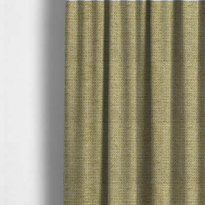 The fabric used to create these made-to-measure curtains is a textured fabric in a warm olive or golden-khaki tone. The material features a tight, rhythmic weave with a prominent tactile surface. The colour is a rich, earthy sage, achieved by interlacing olive-green threads with lighter tan and straw-coloured fibres, creating a weathered, organic look that shifts beautifully in the light.