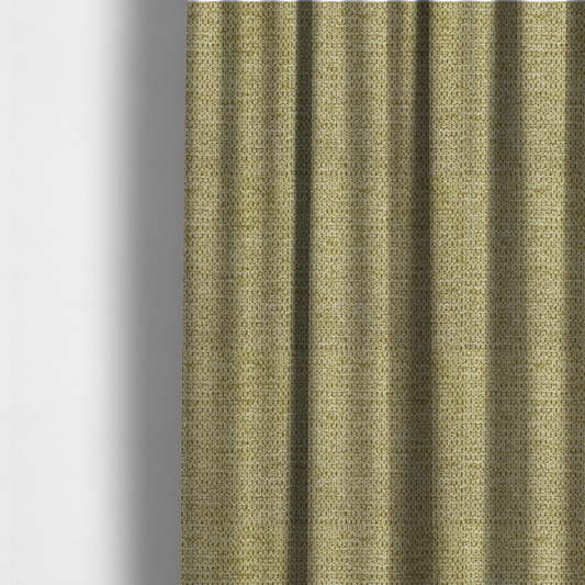 The fabric used to create these made-to-measure curtains is a textured fabric in a warm olive or golden-khaki tone. The material features a tight, rhythmic weave with a prominent tactile surface. The colour is a rich, earthy sage, achieved by interlacing olive-green threads with lighter tan and straw-coloured fibres, creating a weathered, organic look that shifts beautifully in the light.