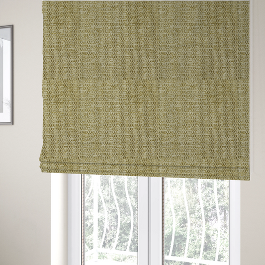 The fabric used to create these Roman blinds is a textured fabric in a warm olive or golden-khaki tone. The material features a tight, rhythmic weave with a prominent tactile surface. The colour is a rich, earthy sage, achieved by interlacing olive-green threads with lighter tan and straw-coloured fibres, creating a weathered, organic look that shifts beautifully in the light.