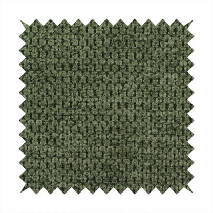 A textured fabric in a deep forest or moss green tone. The material features a dense, rhythmic weave with a prominent tactile surface. The colour is a rich, moody evergreen, achieved by interlacing dark green threads with subtle black or charcoal base fibres, creating a sophisticated, shadowed depth throughout the honeycomb-like pattern.