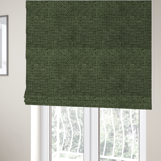 The fabric used to create these Roman blinds is a textured fabric in a deep forest or moss green tone. The material features a dense, rhythmic weave with a prominent tactile surface. The colour is a rich, moody evergreen, achieved by interlacing dark green threads with subtle black or charcoal base fibres, creating a sophisticated, shadowed depth throughout the honeycomb-like pattern.