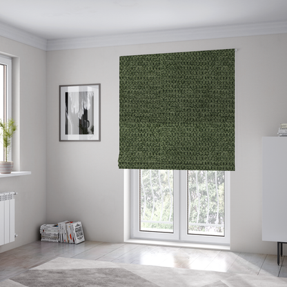 The fabric used to create these Roman blinds is a textured fabric in a deep forest or moss green tone. The material features a dense, rhythmic weave with a prominent tactile surface. The colour is a rich, moody evergreen, achieved by interlacing dark green threads with subtle black or charcoal base fibres, creating a sophisticated, shadowed depth throughout the honeycomb-like pattern.