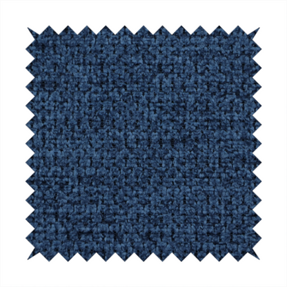 A textured fabric in a deep navy or midnight blue tone. The material features a dense, rhythmic weave with a prominent tactile surface. The colour is a rich, saturated indigo, achieved by interlacing vibrant blue threads with darker charcoal base fibres, creating a sophisticated, shadowed depth throughout the honeycomb-like pattern.