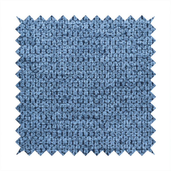 A textured fabric in a serene slate or denim blue tone. This material features a dense, rhythmic weave with a tactile, honeycomb-like surface. The colour is a cool, mid-toned blue, achieved by interlacing cornflower blue threads with darker charcoal base fibres, resulting in a weathered, multidimensional look that feels both calm and sturdy.