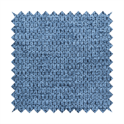 A textured fabric in a serene slate or denim blue tone. This material features a dense, rhythmic weave with a tactile, honeycomb-like surface. The colour is a cool, mid-toned blue, achieved by interlacing cornflower blue threads with darker charcoal base fibres, resulting in a weathered, multidimensional look that feels both calm and sturdy.