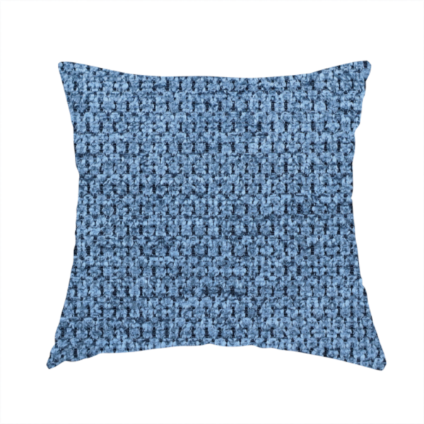 The fabric used to create this handmade cushion is a textured fabric in a serene slate or denim blue tone. This material features a dense, rhythmic weave with a tactile, honeycomb-like surface. The colour is a cool, mid-toned blue, achieved by interlacing cornflower blue threads with darker charcoal base fibres, resulting in a weathered, multidimensional look that feels both calm and sturdy.