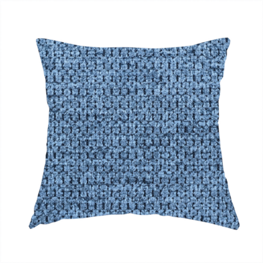 The fabric used to create this handmade cushion is a textured fabric in a serene slate or denim blue tone. This material features a dense, rhythmic weave with a tactile, honeycomb-like surface. The colour is a cool, mid-toned blue, achieved by interlacing cornflower blue threads with darker charcoal base fibres, resulting in a weathered, multidimensional look that feels both calm and sturdy.