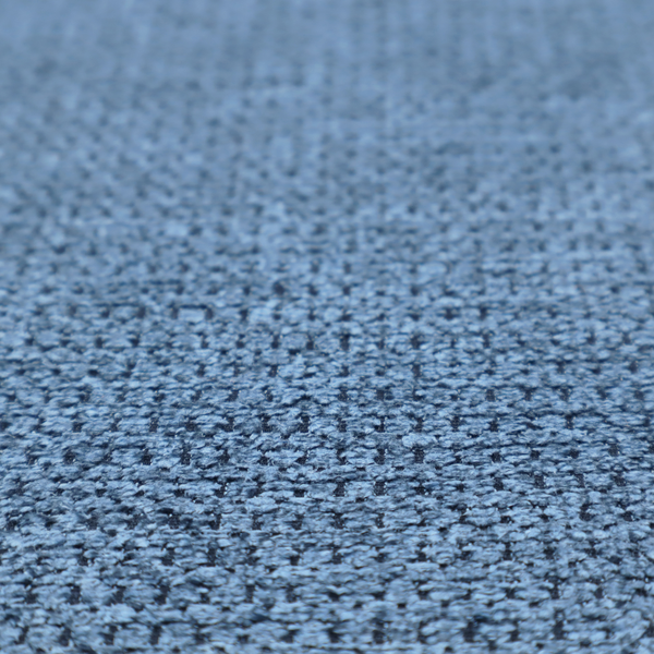 A textured fabric in a serene slate or denim blue tone. This material features a dense, rhythmic weave with a tactile, honeycomb-like surface. The colour is a cool, mid-toned blue, achieved by interlacing cornflower blue threads with darker charcoal base fibres, resulting in a weathered, multidimensional look that feels both calm and sturdy.