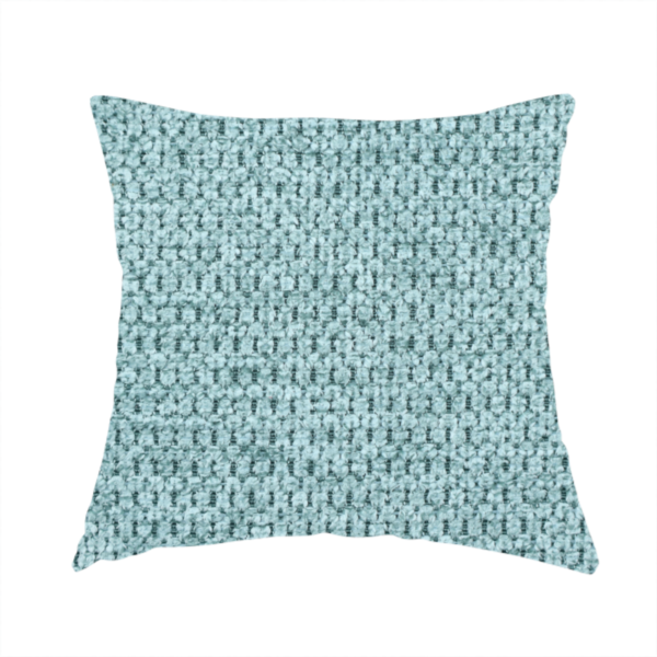 The fabric used to create this handmade cushion is a textured fabric in a vibrant aqua or light teal tone. This material features a dense, rhythmic weave with a prominent tactile surface. The colour is a refreshing seafoam blue, achieved by interlacing bright aqua threads with subtle grey base fibres, creating a weathered, multidimensional look that feels energetic yet sophisticated.