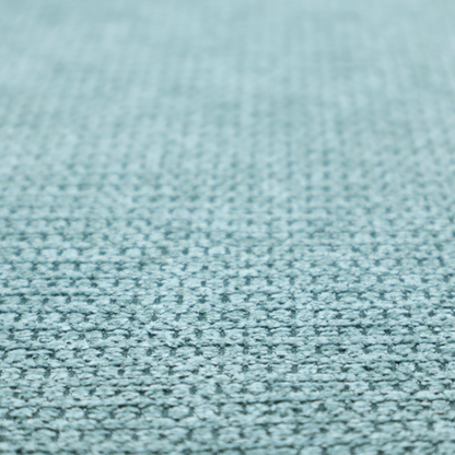 A textured fabric in a vibrant aqua or light teal tone. This material features a dense, rhythmic weave with a prominent tactile surface. The colour is a refreshing seafoam blue, achieved by interlacing bright aqua threads with subtle grey base fibres, creating a weathered, multidimensional look that feels energetic yet sophisticated.