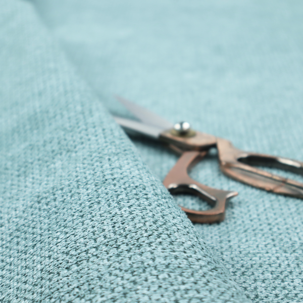 A textured fabric in a vibrant aqua or light teal tone. This material features a dense, rhythmic weave with a prominent tactile surface. The colour is a refreshing seafoam blue, achieved by interlacing bright aqua threads with subtle grey base fibres, creating a weathered, multidimensional look that feels energetic yet sophisticated.