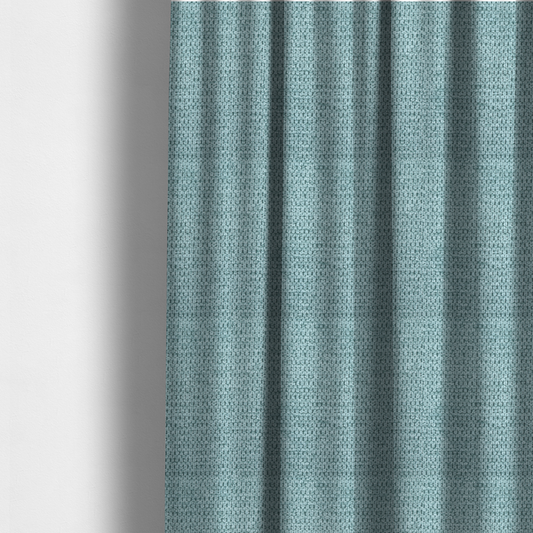 The fabric used to create these made-to-measure curtains is a textured fabric in a vibrant aqua or light teal tone. This material features a dense, rhythmic weave with a prominent tactile surface. The colour is a refreshing seafoam blue, achieved by interlacing bright aqua threads with subtle grey base fibres, creating a weathered, multidimensional look that feels energetic yet sophisticated.