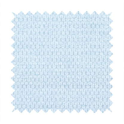 A textured fabric in a pale sky blue. This material features a dense, rhythmic weave with a delicate honeycomb-like surface. The colour is a bright, airy pastel blue, achieved by interlacing soft blue threads with a crisp white base, resulting in a luminous, clean appearance that emphasizes the fabric's tactile grid.