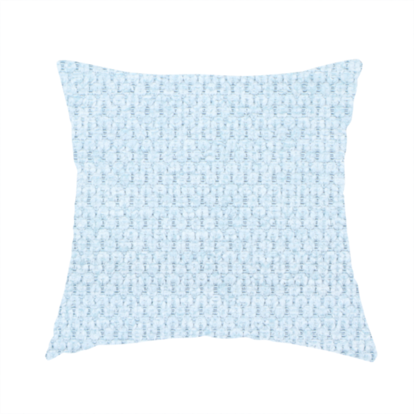 The fabric used to create this handmade cushion is a textured fabric in a pale sky blue. This material features a dense, rhythmic weave with a delicate honeycomb-like surface. The colour is a bright, airy pastel blue, achieved by interlacing soft blue threads with a crisp white base, resulting in a luminous, clean appearance that emphasizes the fabric's tactile grid.