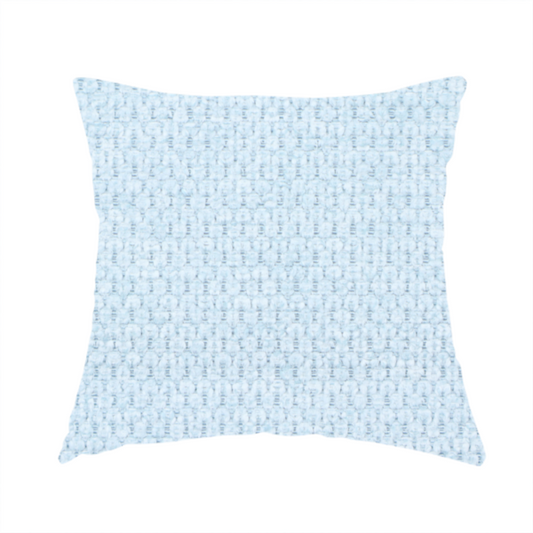The fabric used to create this handmade cushion is a textured fabric in a pale sky blue. This material features a dense, rhythmic weave with a delicate honeycomb-like surface. The colour is a bright, airy pastel blue, achieved by interlacing soft blue threads with a crisp white base, resulting in a luminous, clean appearance that emphasizes the fabric's tactile grid.