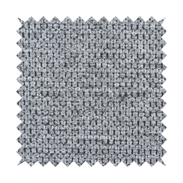 A textured fabric in a classic charcoal or weathered grey. The material features a dense, rhythmic weave with a tactile, pebbled surface. The colour is a sophisticated mid-grey, achieved by interlacing silver-grey threads with darker black base fibres, creating a high-contrast, multidimensional look that feels balanced and durable.