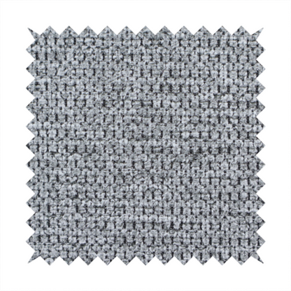 A textured fabric in a classic charcoal or weathered grey. The material features a dense, rhythmic weave with a tactile, pebbled surface. The colour is a sophisticated mid-grey, achieved by interlacing silver-grey threads with darker black base fibres, creating a high-contrast, multidimensional look that feels balanced and durable.