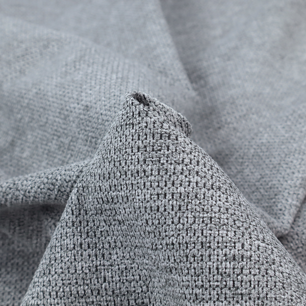 A textured fabric in a classic charcoal or weathered grey. The material features a dense, rhythmic weave with a tactile, pebbled surface. The colour is a sophisticated mid-grey, achieved by interlacing silver-grey threads with darker black base fibres, creating a high-contrast, multidimensional look that feels balanced and durable.