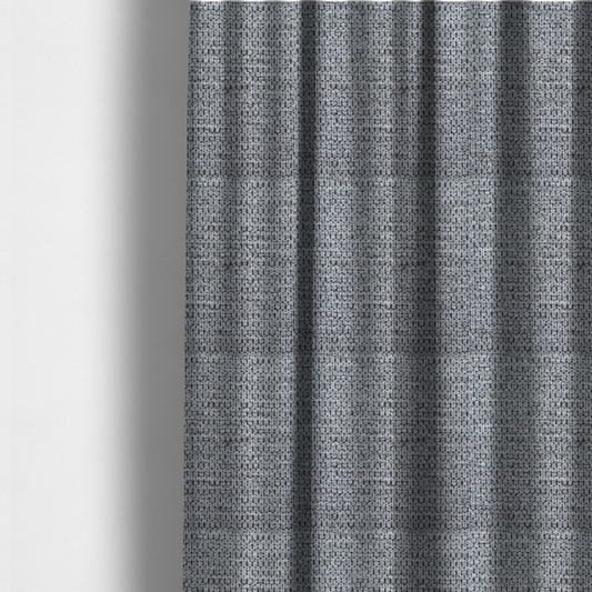 The fabric used to create these made-to-measure curtains is a textured fabric in a classic charcoal or weathered grey. The material features a dense, rhythmic weave with a tactile, pebbled surface. The colour is a sophisticated mid-grey, achieved by interlacing silver-grey threads with darker black base fibres, creating a high-contrast, multidimensional look that feels balanced and durable.