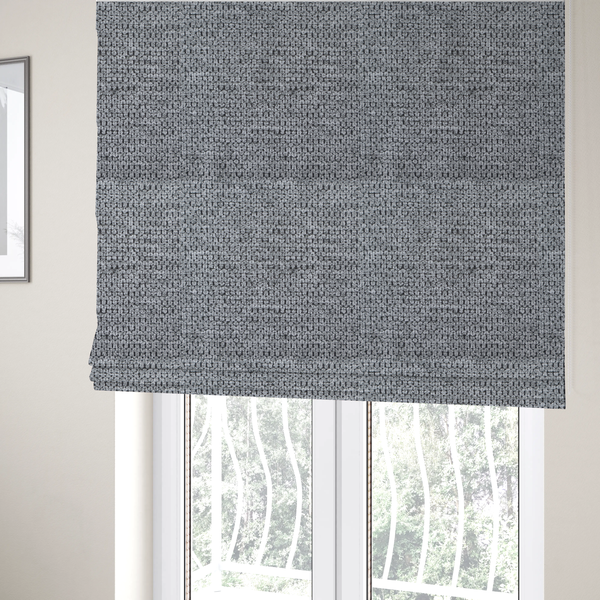 The fabric used to create these Roman blinds is a textured fabric in a classic charcoal or weathered grey. The material features a dense, rhythmic weave with a tactile, pebbled surface. The colour is a sophisticated mid-grey, achieved by interlacing silver-grey threads with darker black base fibres, creating a high-contrast, multidimensional look that feels balanced and durable.