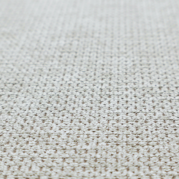 A textured fabric in light greige or pale oatmeal. The material features a dense, rhythmic honeycomb weave. The colour is achieved by interlacing light cream threads with cool grey base fibres, creating a neutral, stony appearance with a soft, pebbled tactile surface.