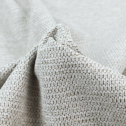 A textured fabric in light greige or pale oatmeal. The material features a dense, rhythmic honeycomb weave. The colour is achieved by interlacing light cream threads with cool grey base fibres, creating a neutral, stony appearance with a soft, pebbled tactile surface.