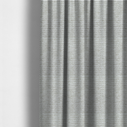 The fabric used to create these made-to-measure curtains is a textured fabric in light greige or pale oatmeal. The material features a dense, rhythmic honeycomb weave. The colour is achieved by interlacing light cream threads with cool grey base fibres, creating a neutral, stony appearance with a soft, pebbled tactile surface.