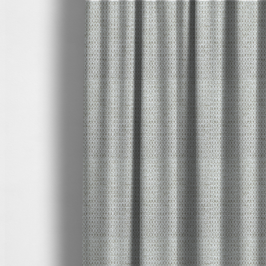 The fabric used to create these made-to-measure curtains is a textured fabric in light greige or pale oatmeal. The material features a dense, rhythmic honeycomb weave. The colour is achieved by interlacing light cream threads with cool grey base fibres, creating a neutral, stony appearance with a soft, pebbled tactile surface.