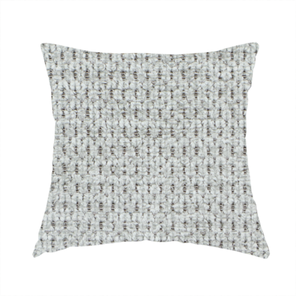 The fabric used to create this handmade cushion is a textured fabric in a soft dove grey. This swatch features the signature uniform honeycomb weave, but with a lighter, more silver-toned profile than the previous neutral. The interlacing of white and light grey threads gives it a crisp, clean, and airy aesthetic.