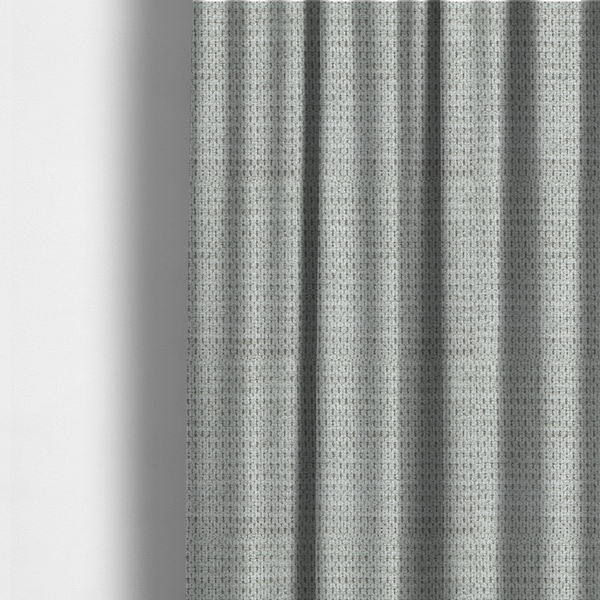 The fabric used to create these made-to-measure curtains is a textured fabric in a soft dove grey. This swatch features the signature uniform honeycomb weave, but with a lighter, more silver-toned profile than the previous neutral. The interlacing of white and light grey threads gives it a crisp, clean, and airy aesthetic.
