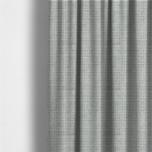 The fabric used to create these made-to-measure curtains is a textured fabric in a soft dove grey. This swatch features the signature uniform honeycomb weave, but with a lighter, more silver-toned profile than the previous neutral. The interlacing of white and light grey threads gives it a crisp, clean, and airy aesthetic.