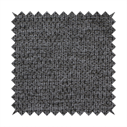 A textured fabric in a deep charcoal or soft black tone. This swatch features the signature rhythmic honeycomb weave of the collection. The colour is a rich, dark obsidian, achieved by tightly interlacing black threads with very subtle dark grey highlights, creating a moody, high-relief surface that absorbs and reflects light in a sophisticated, matte-metallic way.