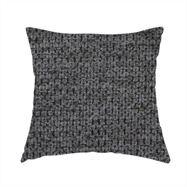 The fabric used to create this handmade cushion is a textured fabric in a deep charcoal or soft black tone. This swatch features the signature rhythmic honeycomb weave of the collection. The colour is a rich, dark obsidian, achieved by tightly interlacing black threads with very subtle dark grey highlights, creating a moody, high-relief surface that absorbs and reflects light in a sophisticated, matte-metallic way.