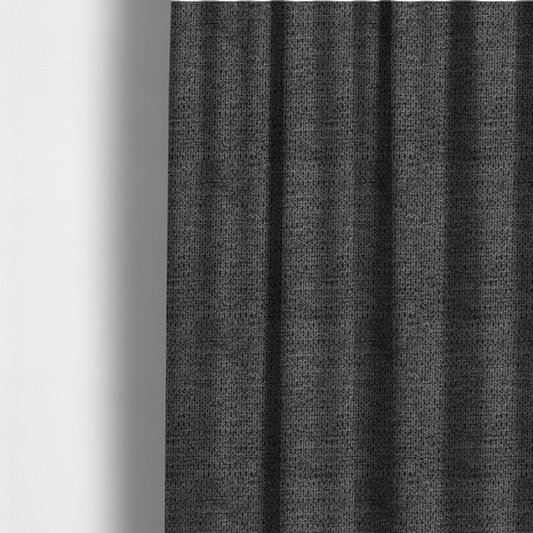 The fabric used to create these made-to-measure curtains is a textured fabric in a deep charcoal or soft black tone. This swatch features the signature rhythmic honeycomb weave of the collection. The colour is a rich, dark obsidian, achieved by tightly interlacing black threads with very subtle dark grey highlights, creating a moody, high-relief surface that absorbs and reflects light in a sophisticated, matte-metallic way.