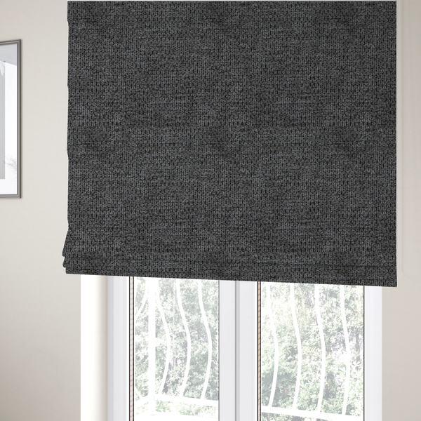 The fabric used to create these Roman blinds is a textured fabric in a deep charcoal or soft black tone. This swatch features the signature rhythmic honeycomb weave of the collection. The colour is a rich, dark obsidian, achieved by tightly interlacing black threads with very subtle dark grey highlights, creating a moody, high-relief surface that absorbs and reflects light in a sophisticated, matte-metallic way.