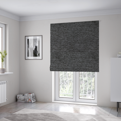 The fabric used to create these Roman blinds is a textured fabric in a deep charcoal or soft black tone. This swatch features the signature rhythmic honeycomb weave of the collection. The colour is a rich, dark obsidian, achieved by tightly interlacing black threads with very subtle dark grey highlights, creating a moody, high-relief surface that absorbs and reflects light in a sophisticated, matte-metallic way.