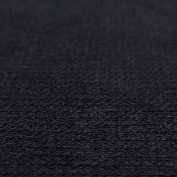 A textured fabric in midnight black. This swatch represents the deepest tone in the collection, featuring a uniform, tight waffle-weave. The monochromatic black threads create a subtle play of shadow within the geometric grid, offering a sleek, architectural aesthetic.