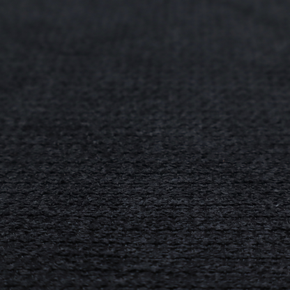 A textured fabric in midnight black. This swatch represents the deepest tone in the collection, featuring a uniform, tight waffle-weave. The monochromatic black threads create a subtle play of shadow within the geometric grid, offering a sleek, architectural aesthetic.