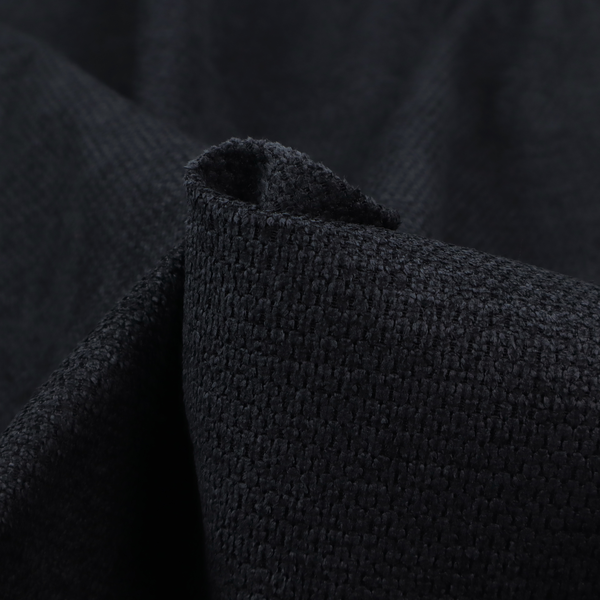 A textured fabric in midnight black. This swatch represents the deepest tone in the collection, featuring a uniform, tight waffle-weave. The monochromatic black threads create a subtle play of shadow within the geometric grid, offering a sleek, architectural aesthetic.