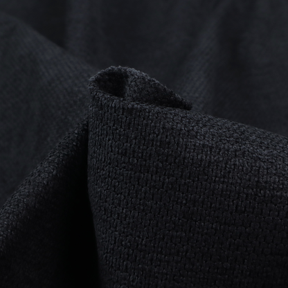 A textured fabric in midnight black. This swatch represents the deepest tone in the collection, featuring a uniform, tight waffle-weave. The monochromatic black threads create a subtle play of shadow within the geometric grid, offering a sleek, architectural aesthetic.