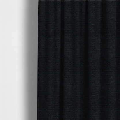 The fabric used to create these made-to-measure curtains is a textured fabric in midnight black. This swatch represents the deepest tone in the collection, featuring a uniform, tight waffle-weave. The monochromatic black threads create a subtle play of shadow within the geometric grid, offering a sleek, architectural aesthetic.