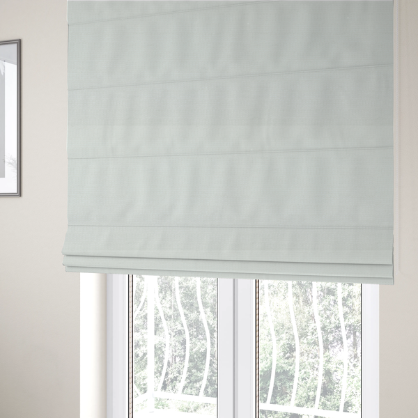 The fabric used to create these Roman blinds is a pale off-white or cream-colored fabric featuring a fine, subtle grid-like texture. The weave consists of horizontal and vertical threads that create a soft, matte finish with a minimalist, clean aesthetic.