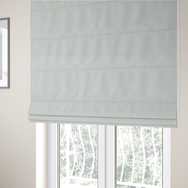 The fabric used to create these Roman blinds is a off-white fabric with a prominent horizontal ribbed texture. The weave features thicker, raised cream threads that create a subtle striped effect on a matte, textured surface, ideal for modern interior design.