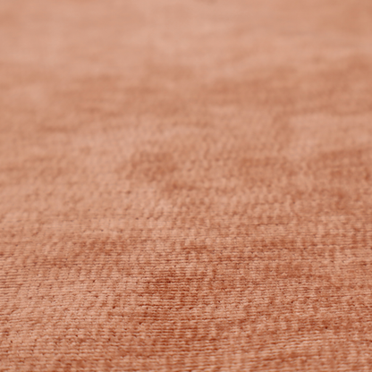A burnt orange fabric with a dense, horizontal corded texture. The weave has a soft, plush pile similar to corduroy, creating a rich tonal depth with warm highlights and subtle shadows across the linear pattern.