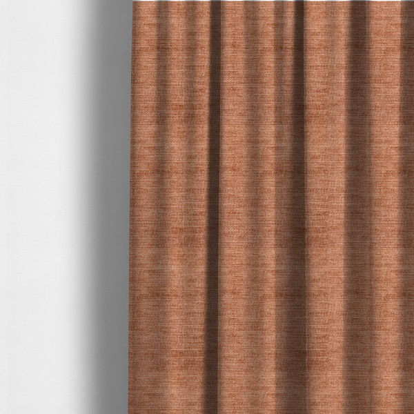 The fabric used to create these made-to-measure curtains is a burnt orange fabric with a dense, horizontal corded texture. The weave has a soft, plush pile similar to corduroy, creating a rich tonal depth with warm highlights and subtle shadows across the linear pattern.