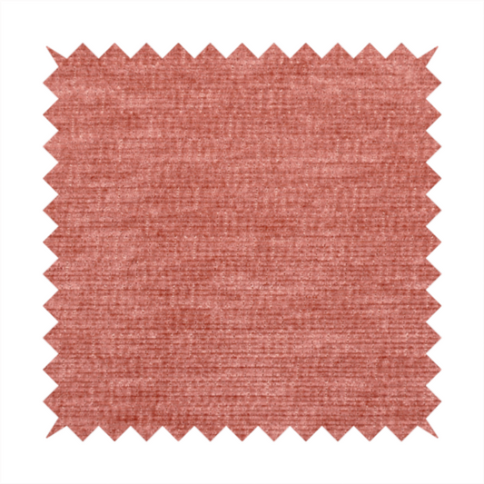 A dusty rose or salmon-pink fabric with a soft, multi-directional texture. While it maintains a subtle horizontal grain, the weave is more flecked and feathered than previous styles, creating a plush, velvet-like surface with organic light-catching highlights.